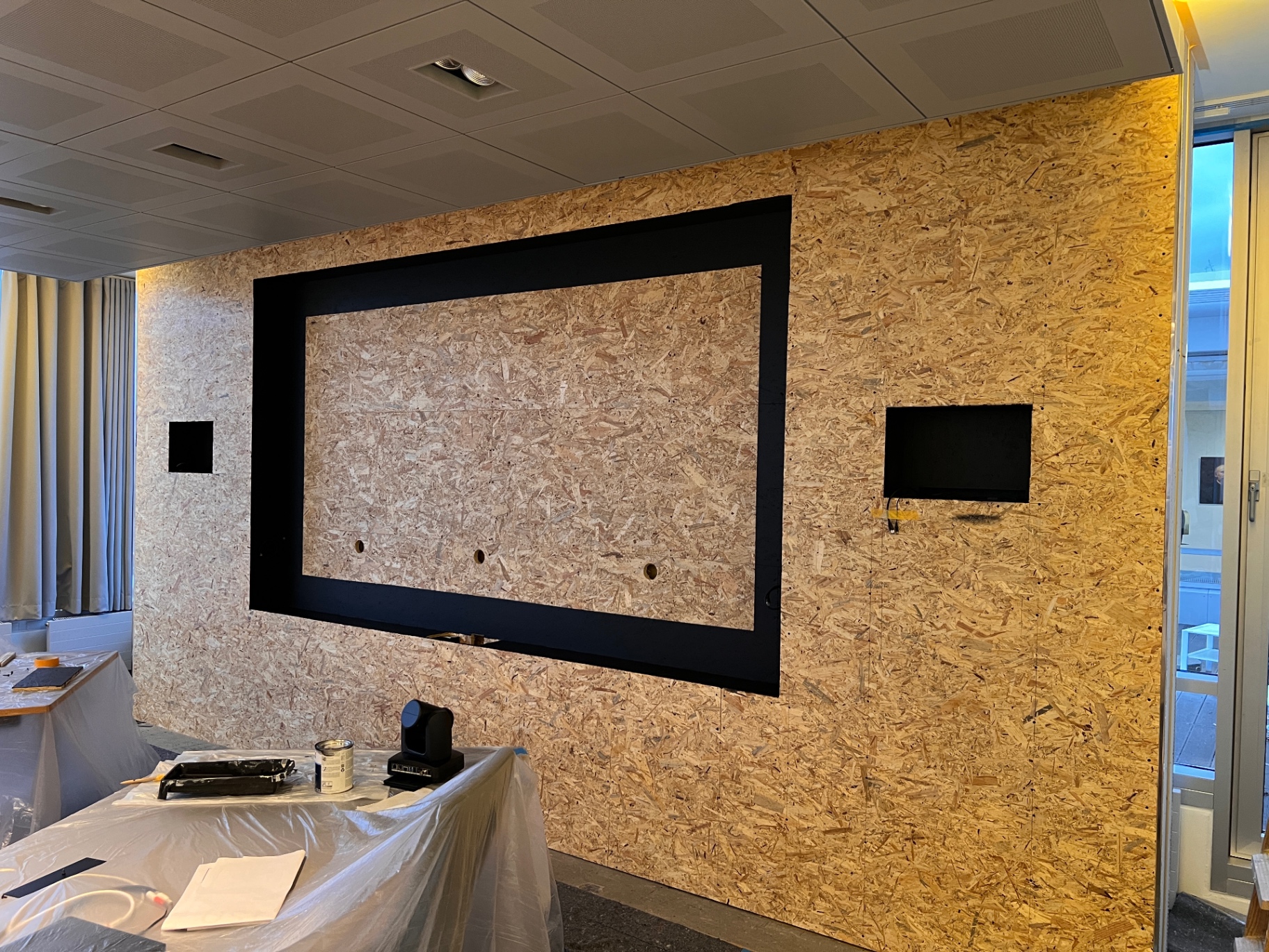 OSB-Substruktur mit schwarzem Rahmen und Kamera-Ausschnitten