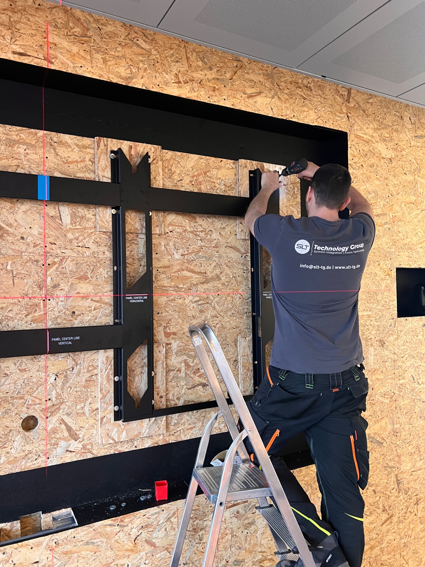 Techniker montiert Bracket-Schienen mit Kreuzlaser